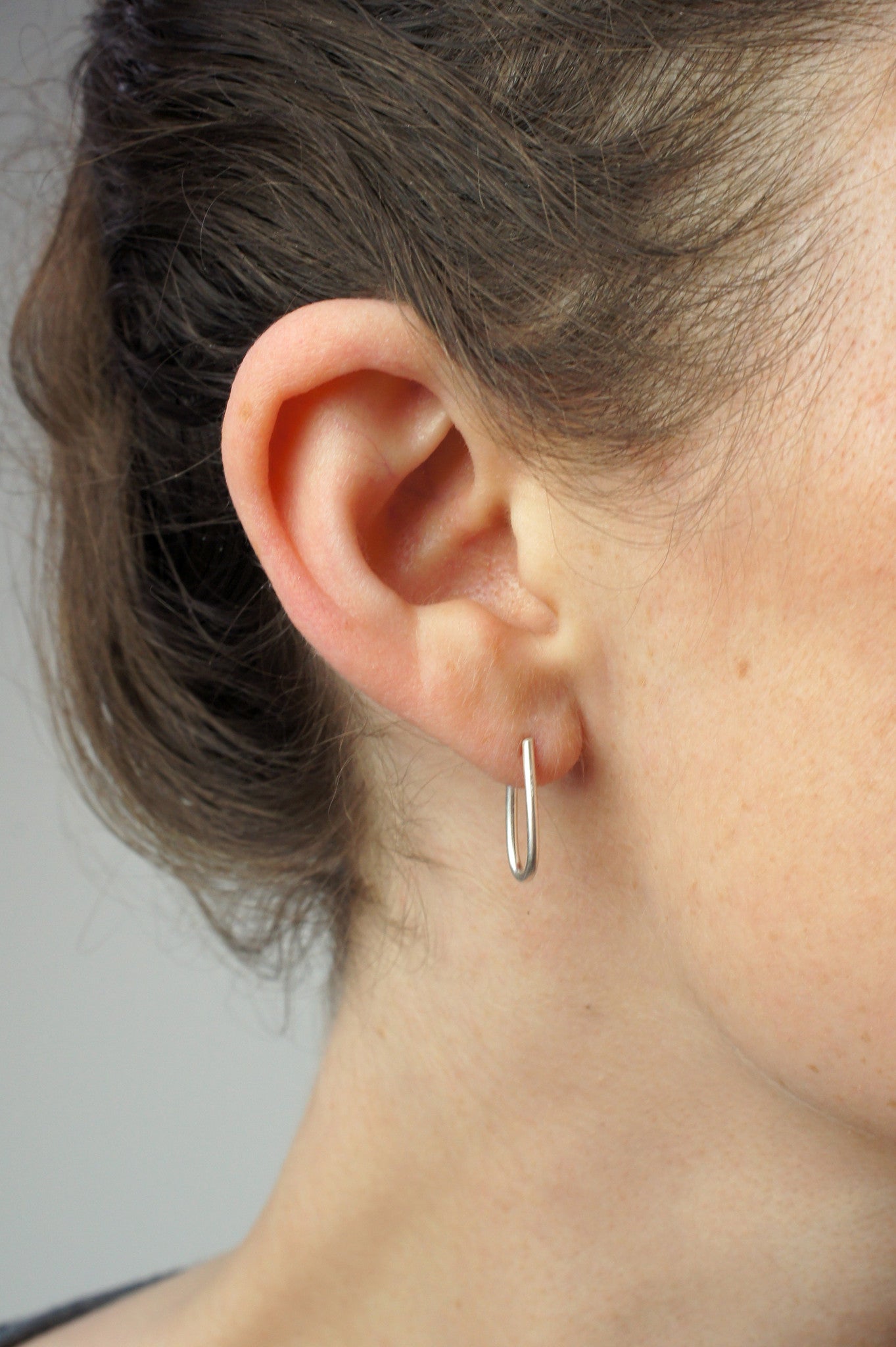 tiny petal silver hoop earrings being worn